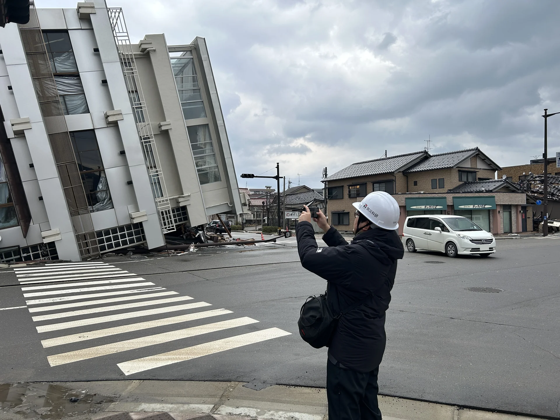 輪島市の現地調査で、ヘルメットを着用した人が建物を記録している様子。