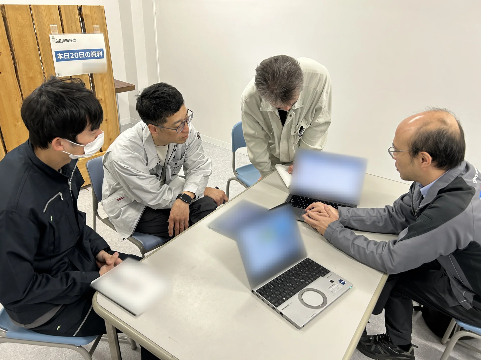 被災市町村の職員と、ノートパソコンやタブレットを囲んで業務を検討している様子。
